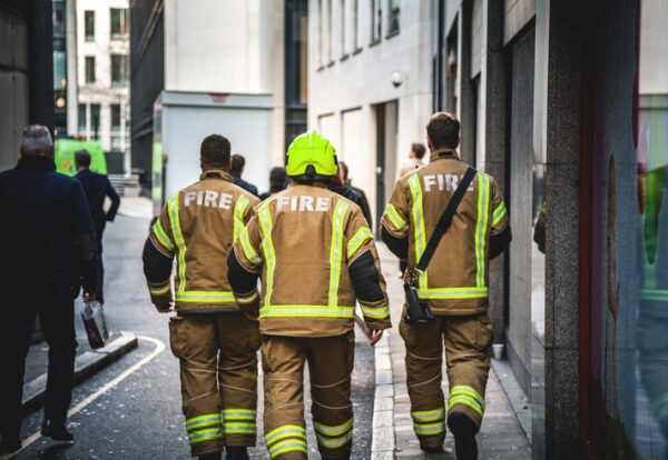 Three firefighters walking in London. Shot early morning.